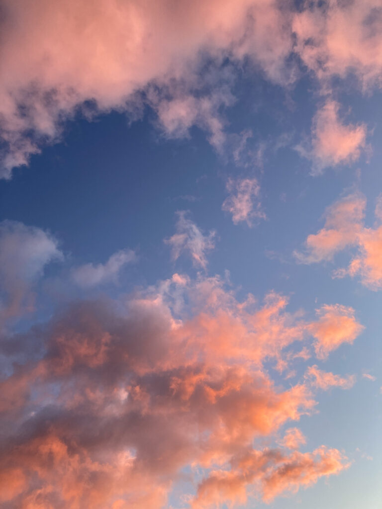 Bright pink clouds against a blue sky, taken at sunset