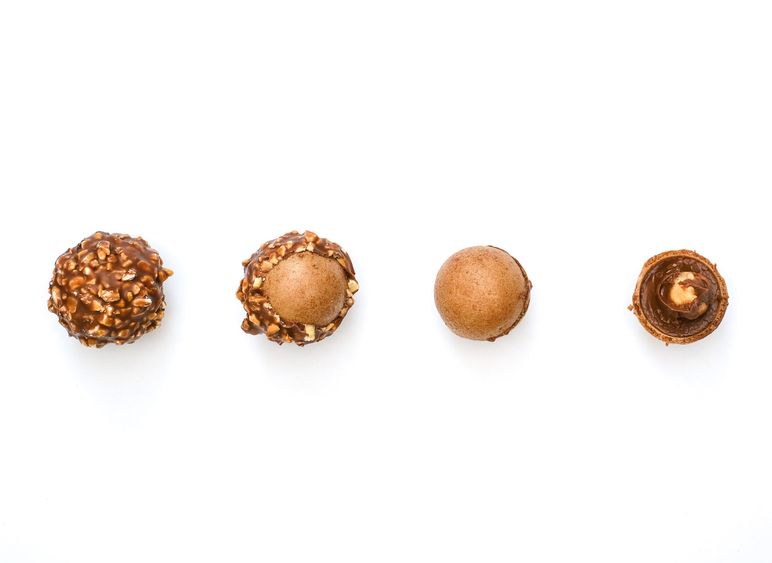 Eating suggestion. Photograph showing 4 stages of eating a Ferrero Rocher, left to right: the outer chocolate and hazelnut shell, second shows part of the shell removed to show the wafer below, third all the shell has been removed to just show wafer, fourth the wafer is part removed to show soft chocolate and a hazelnut within.
