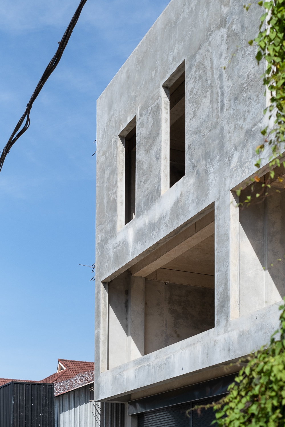 Photograph of a building underconstruction - the spaces for windows look like a pair of rectangular eyes and wide open mouth.