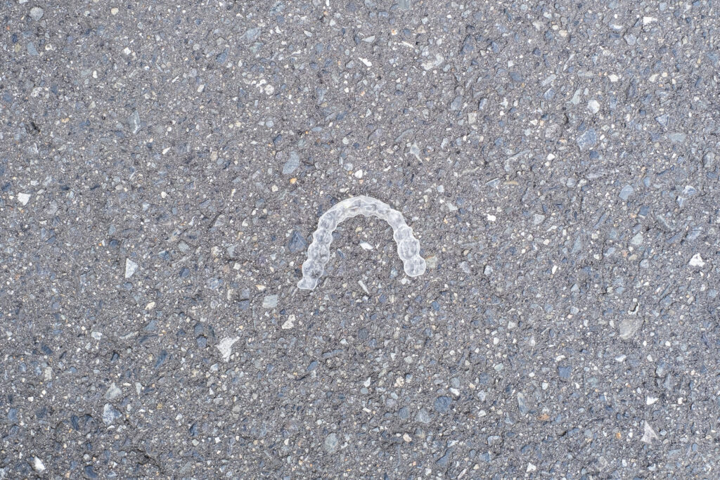 Photograph of a retainer/tooth alignment device on a concrete floor.