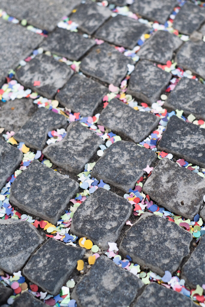 Photograph of colourful confetti between cobble stones, Munich, Germany.