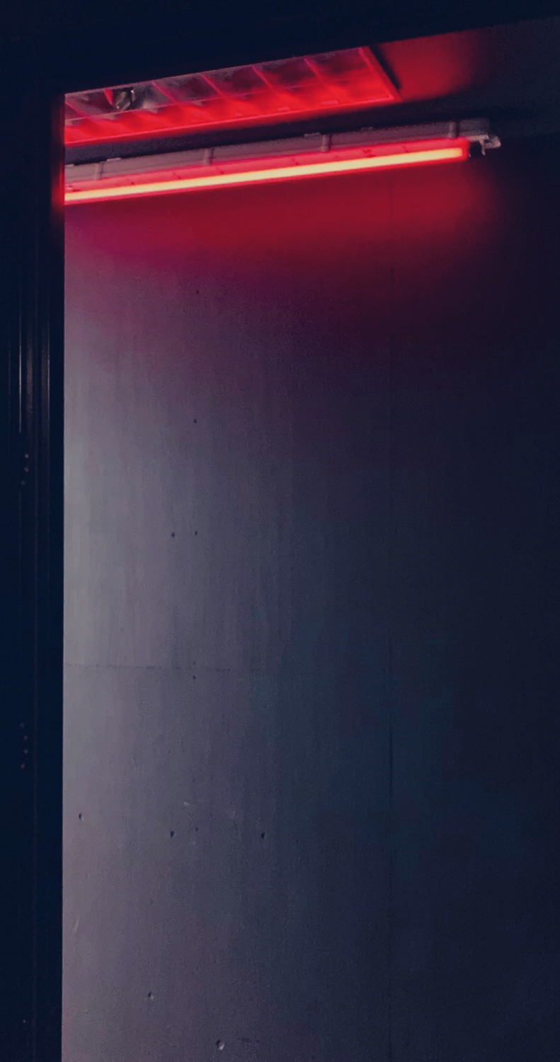 Photograph of a red strip light on a black wall