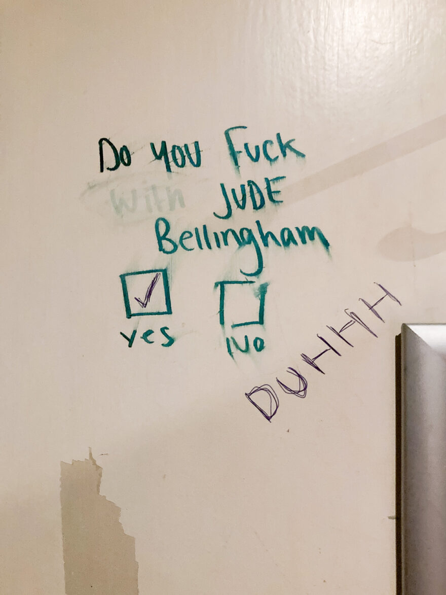 London, UK, July 2024. Photograph of writing on the back of a door that says 'Do you fuck (with is rubbed out) Jude Bellingham' with boxes with 'yes' and 'no' underneath, the yes box ticked and ' DUHHH' added beneath.