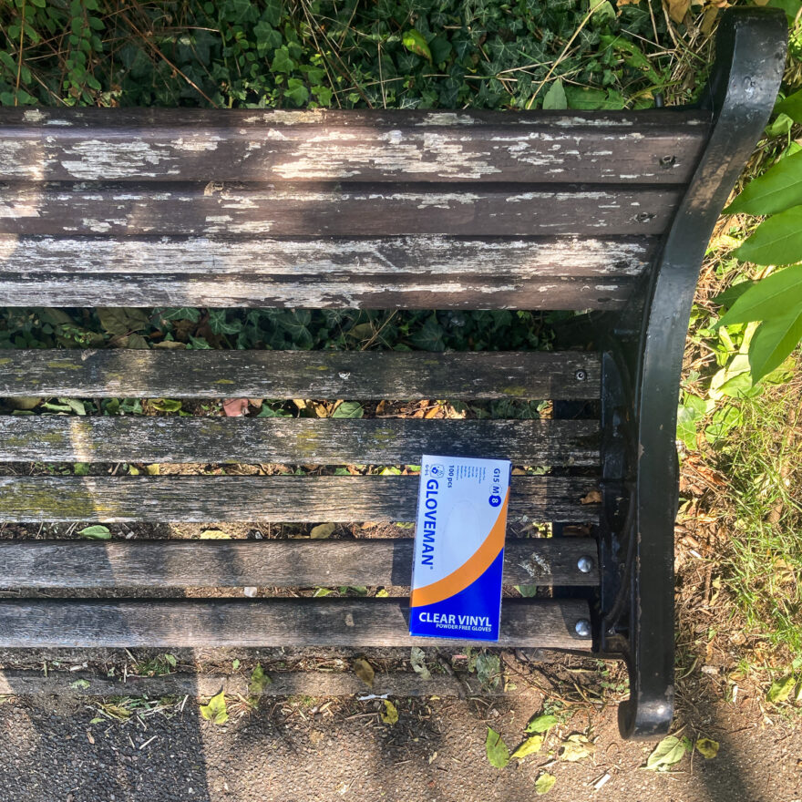 Colchester, UK, September 2024. Photograph looking down at a wooden bench with a box of 'Gloveman' Clear Vinyl gloves on it.