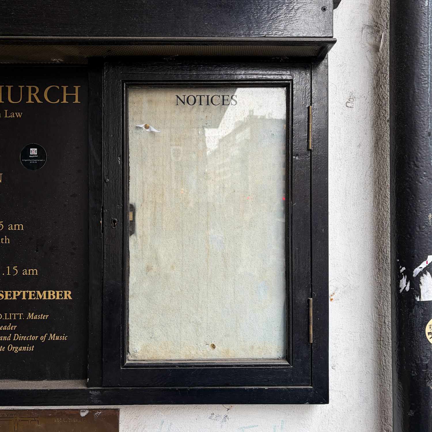 Photograph of an empty black wooden frame with 'NOTICES' at the top.
